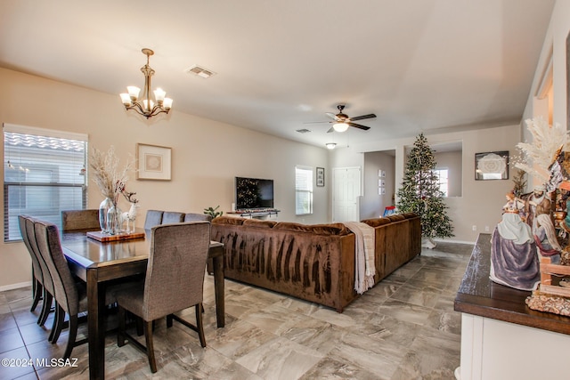 dining space with a healthy amount of sunlight and ceiling fan with notable chandelier