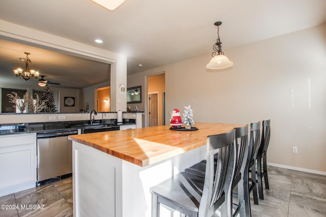 kitchen with dishwasher, wooden counters, sink, hanging light fixtures, and ceiling fan