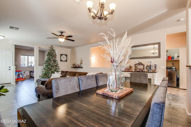 tiled dining room with ceiling fan with notable chandelier and washer / dryer