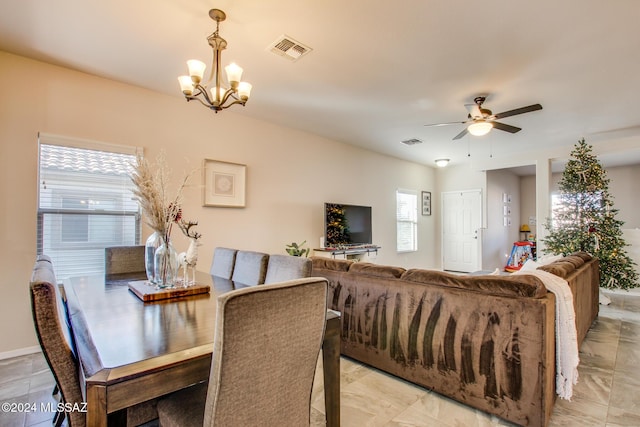 dining room with ceiling fan with notable chandelier and plenty of natural light