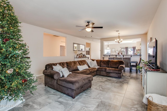 living room featuring ceiling fan with notable chandelier