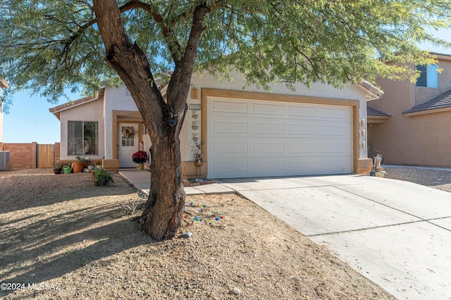 ranch-style house featuring cooling unit and a garage