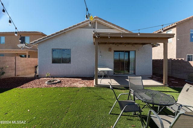 rear view of house featuring a patio area and a yard