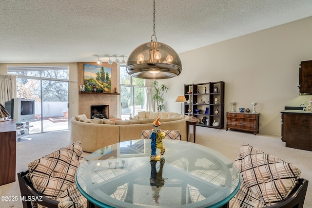 dining space featuring a large fireplace, a textured ceiling, and a healthy amount of sunlight