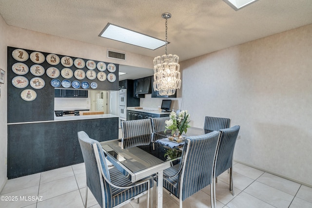 dining space featuring an inviting chandelier, light tile patterned floors, and visible vents