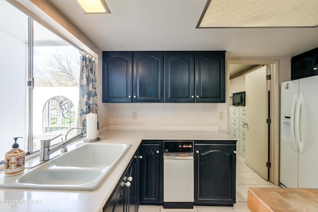 kitchen featuring white fridge with ice dispenser, light countertops, a sink, and light tile patterned flooring