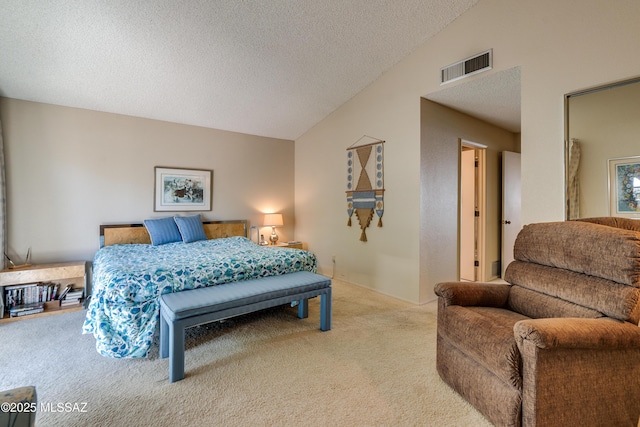 carpeted bedroom featuring lofted ceiling, a textured ceiling, and visible vents