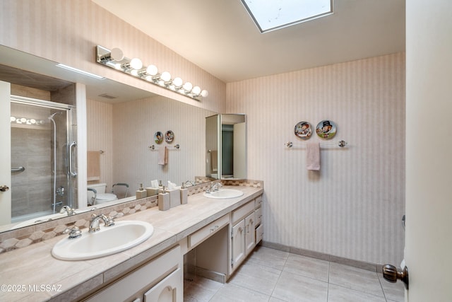 bathroom with tile patterned floors, a sink, toilet, and wallpapered walls