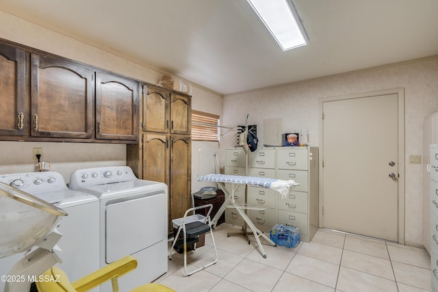 laundry area with washer and dryer, cabinet space, and light tile patterned floors