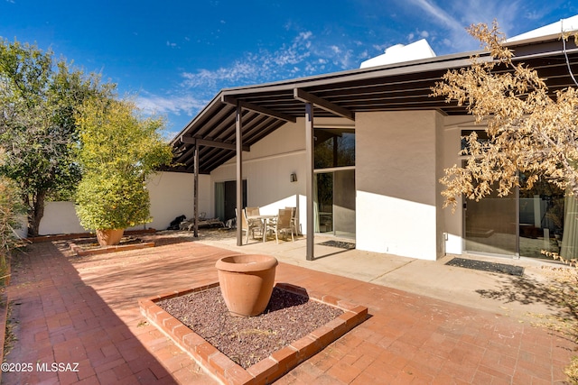 rear view of property featuring stucco siding and a patio