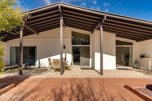 rear view of property featuring a patio and stucco siding