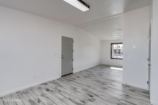 unfurnished room with light wood-type flooring, vaulted ceiling, and ceiling fan