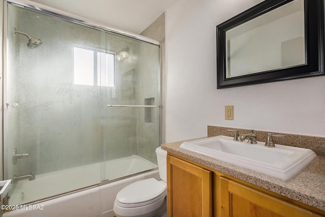 full bathroom featuring combined bath / shower with glass door, toilet, and vanity