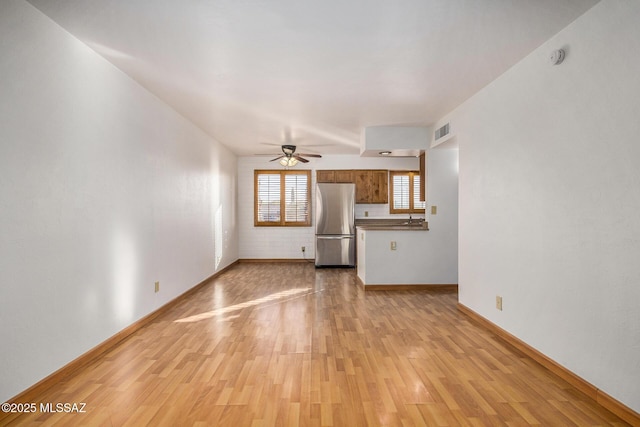 unfurnished living room featuring light hardwood / wood-style floors and ceiling fan