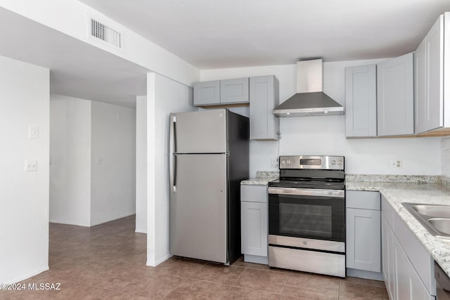 kitchen featuring appliances with stainless steel finishes, wall chimney exhaust hood, sink, gray cabinets, and light tile patterned flooring