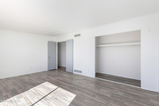 unfurnished bedroom featuring hardwood / wood-style floors and a closet