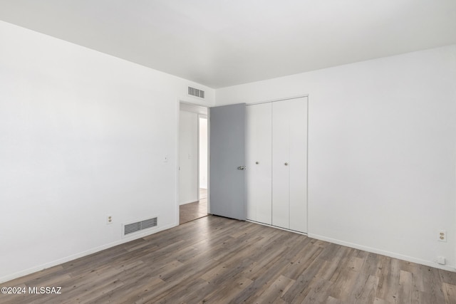 unfurnished bedroom with hardwood / wood-style flooring and a closet