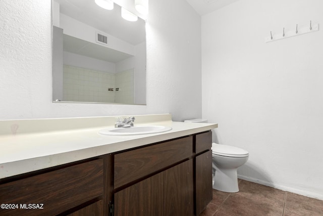 bathroom with tile patterned flooring, vanity, and toilet