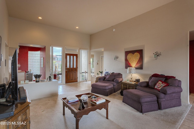 living room with a towering ceiling and light tile patterned flooring