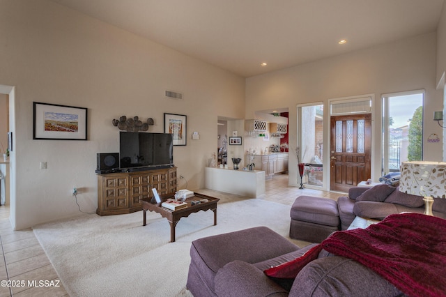 living room featuring light tile patterned flooring and a towering ceiling