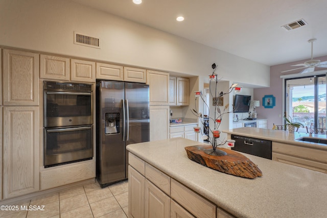 kitchen featuring light brown cabinets, sink, ceiling fan, light tile patterned floors, and appliances with stainless steel finishes