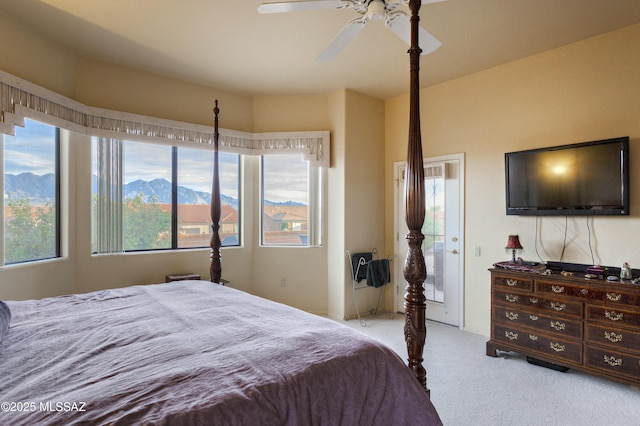 bedroom featuring multiple windows, light carpet, and ceiling fan