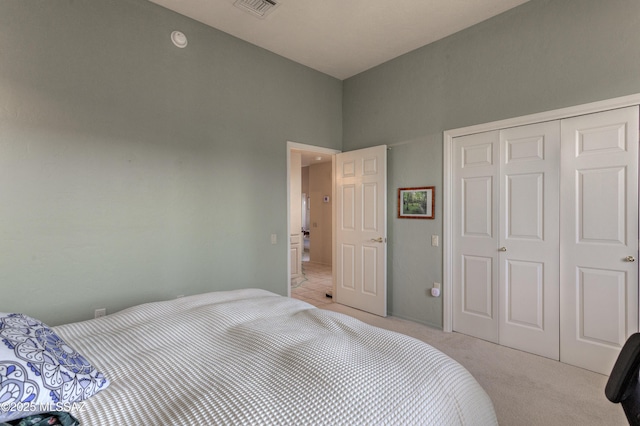 bedroom with light carpet and a closet