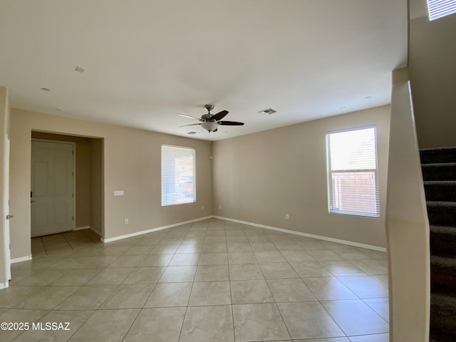 tiled spare room with ceiling fan