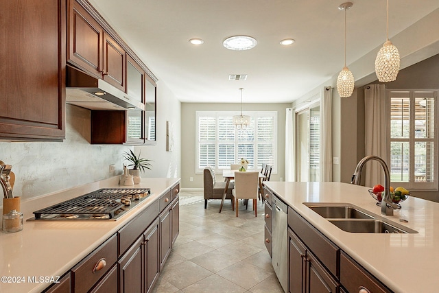 kitchen featuring a chandelier, a wealth of natural light, hanging light fixtures, and sink