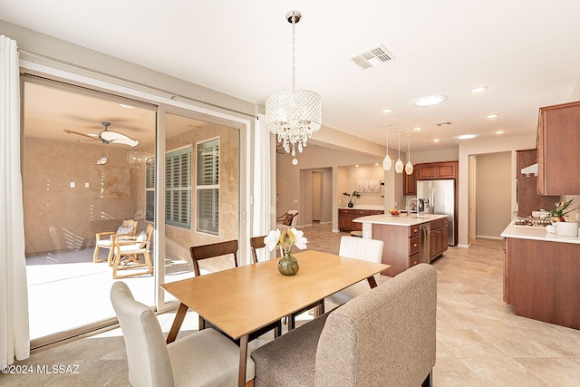 dining room with sink and ceiling fan with notable chandelier