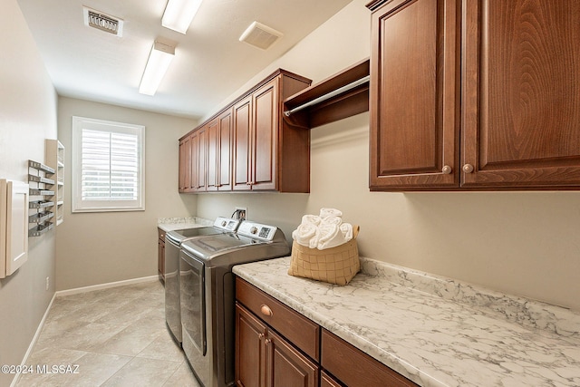 laundry area featuring separate washer and dryer and cabinets