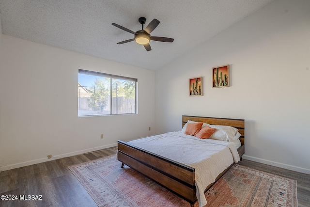 bedroom with a textured ceiling, ceiling fan, dark wood-type flooring, and lofted ceiling