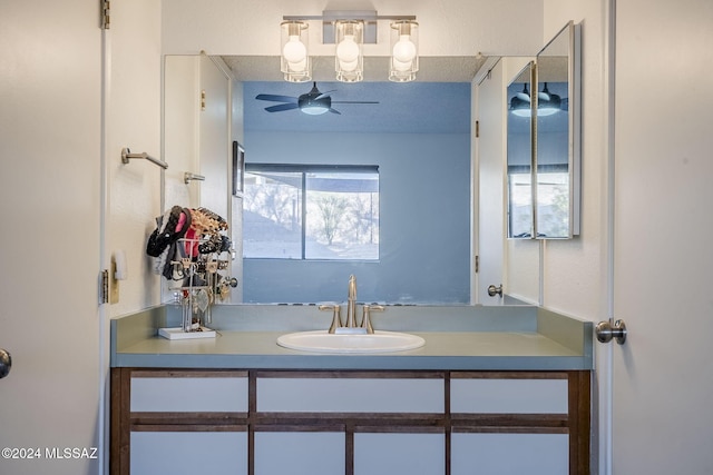 bathroom featuring vanity, ceiling fan, and a textured ceiling