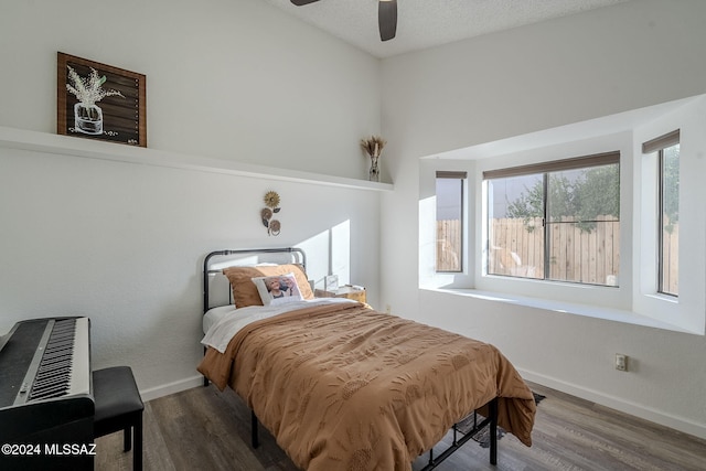 bedroom featuring hardwood / wood-style floors, a textured ceiling, and ceiling fan