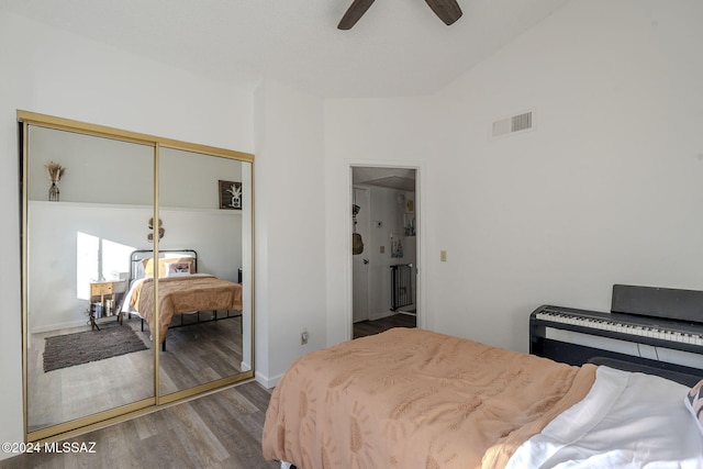 bedroom with ceiling fan, light hardwood / wood-style floors, lofted ceiling, and a closet