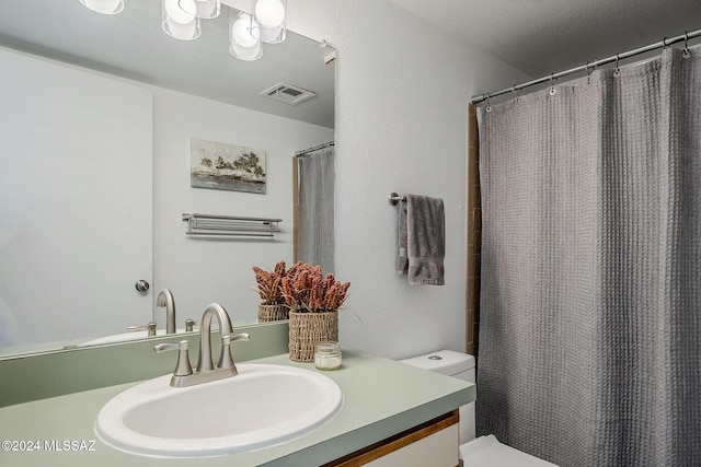 bathroom with vanity, curtained shower, and toilet