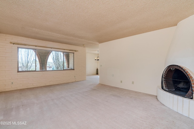 unfurnished living room featuring a textured ceiling, carpet floors, and a fireplace