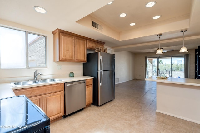 kitchen with a sink, visible vents, hanging light fixtures, appliances with stainless steel finishes, and a raised ceiling