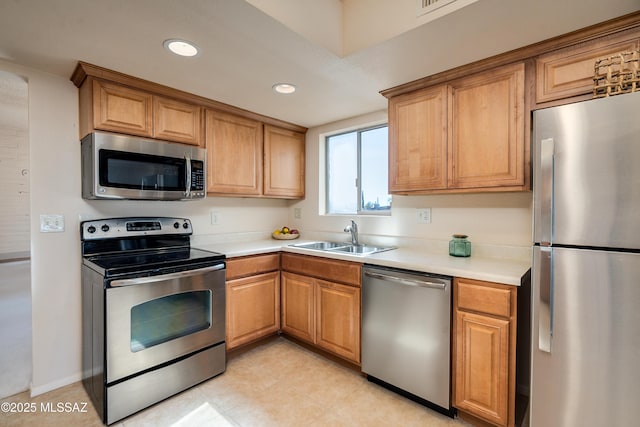 kitchen featuring recessed lighting, stainless steel appliances, a sink, and light countertops