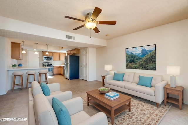 living area with light tile patterned floors, visible vents, and a ceiling fan