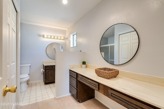 bathroom with baseboards, vanity, and toilet