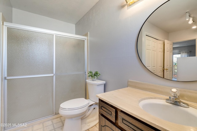 bathroom with toilet, a stall shower, and vanity