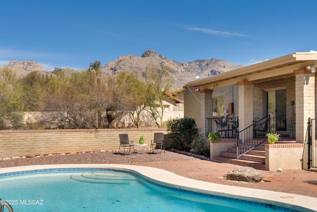 view of pool with a fenced in pool, a patio area, a mountain view, and fence