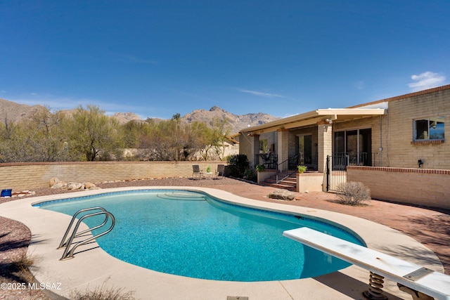 view of pool featuring a patio, fence, a mountain view, and a fenced in pool