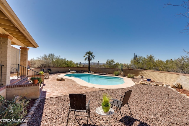 view of swimming pool with a fenced backyard, a diving board, a fenced in pool, and a patio