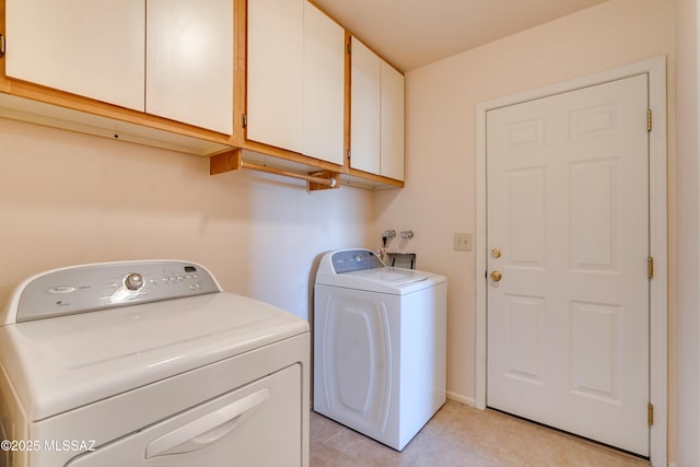 laundry area with light tile patterned floors, separate washer and dryer, and cabinet space