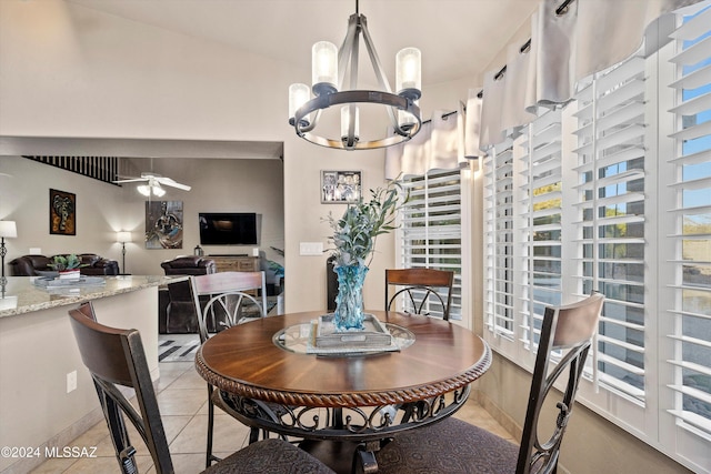 tiled dining space featuring ceiling fan with notable chandelier