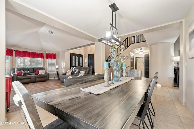 tiled dining area featuring vaulted ceiling