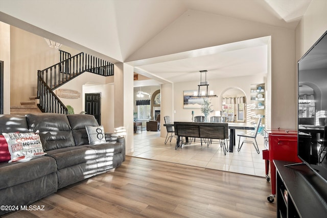 living room with wood-type flooring, lofted ceiling, and a notable chandelier