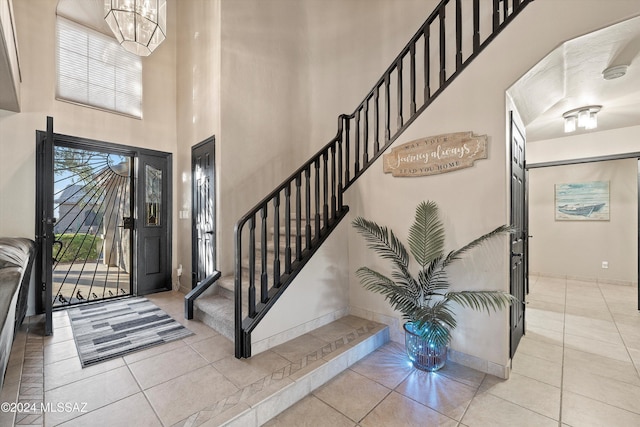 entryway with light tile patterned floors and a notable chandelier